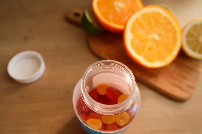 maria-kozyr-KQBX7YTcGuc-unsplash | Tel Aviv Doctor A jar of vitamin gummies beside fresh oranges — dietary supplements